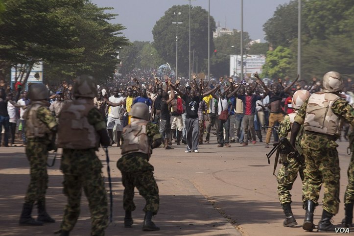 1024px-Soldiers_attempt_to_stop_protesters_from_entering_the_parliament_building_in_Ouagadougou,_Oct._30,_2014.jpg